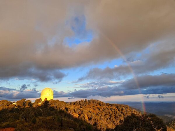 The Anglo Australian Telescope with rainbow and dramatic skies at Siding Spring Observatory in New South Wales, Australia.
