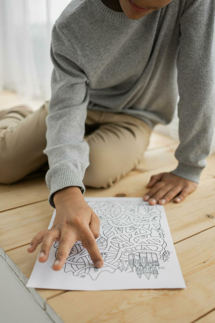 Child solving a labyrinth on paper