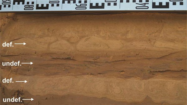 Teadlaste poolt tagaotsitavad moonutatud settekihid (märgitud def.). Foto pärineb kvaternaari liivakarjäärist Lätis.