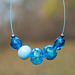 Türkiissiniste klaaskuulidega ehe sinisel võrul, 4 läbipaistvat ja 1 opaalne kuul
