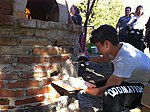 Italian students practice plastering a pizza oven
