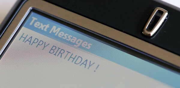 Текстовое сообщение с днем ​​рождения отображается на экране мобильного телефона