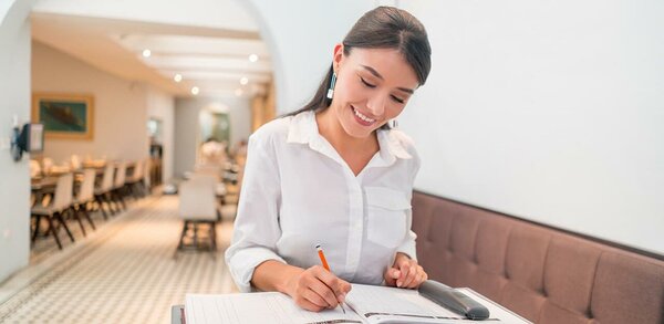 Woman taking bookings in a restaurant