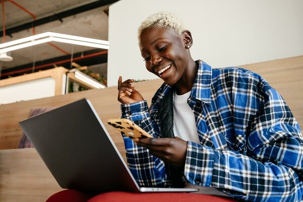Black woman in flannel looking at a smartphone