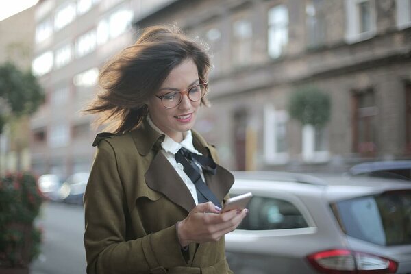 Woman in a green coat scrolling her smartphone