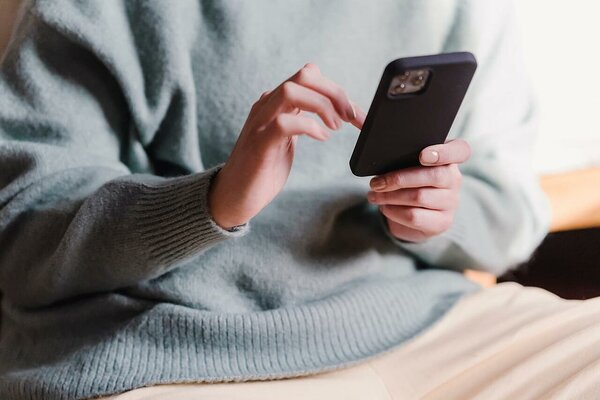 Woman in a sweatshirt using a smartphone