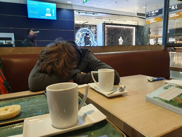 tired tourist at transit airport, lot of noise