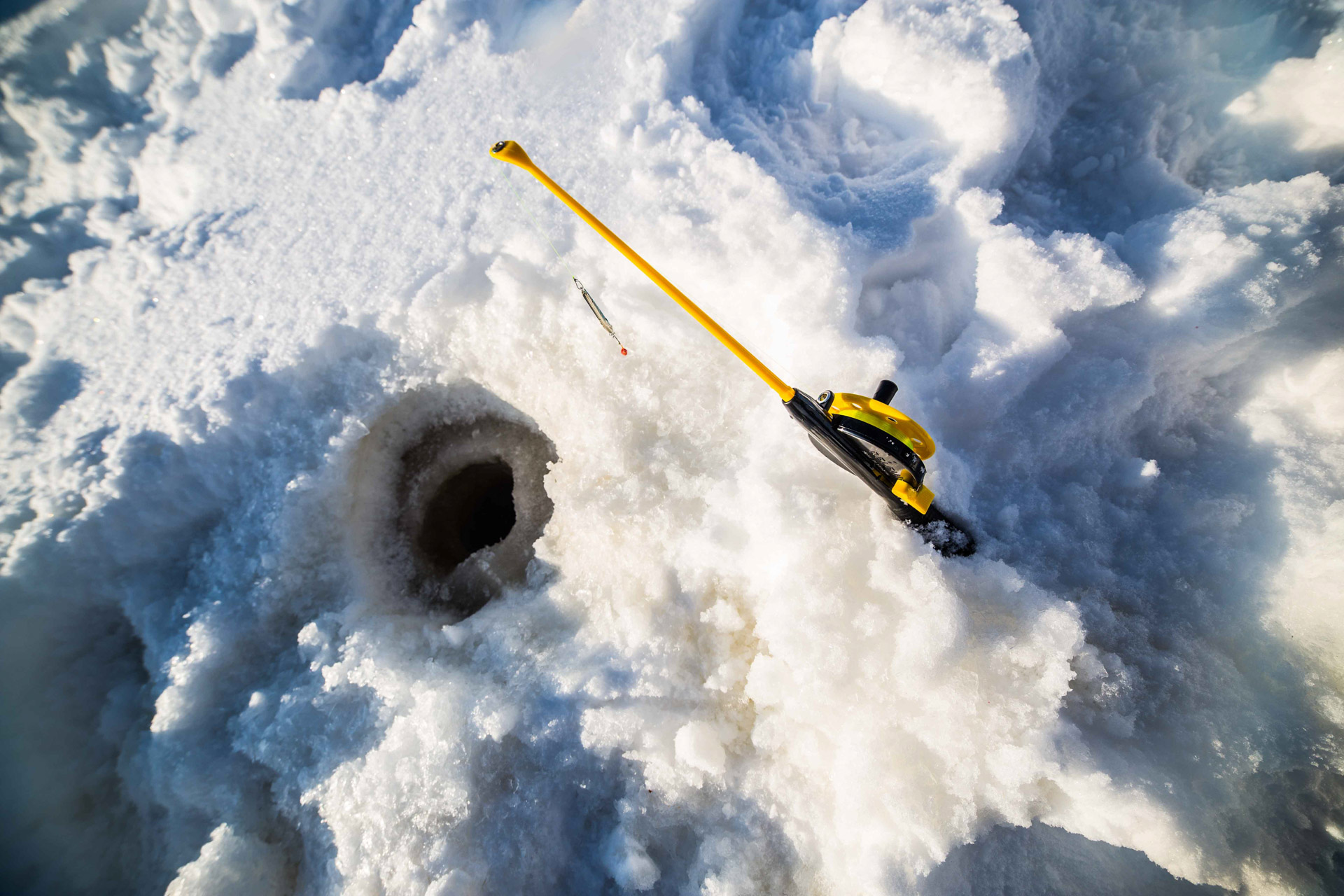 Ice fishing on a frozen lake Beyond Arctic Rovaniemi
