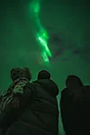 Family watching the Northern Lights on a cloudy night in Rovaniemi Lapland Finland