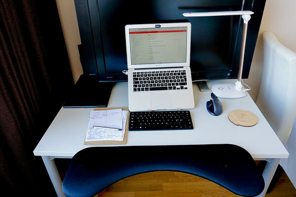 See on minu ergonoomiline kodukontor: randmetugi, sülearvutikõrgendus, ergonoomiline hiir ja klaviatuur, reguleeritava valgusega lamp.
