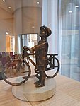 Escultura del niño en bicicleta en miniatura.