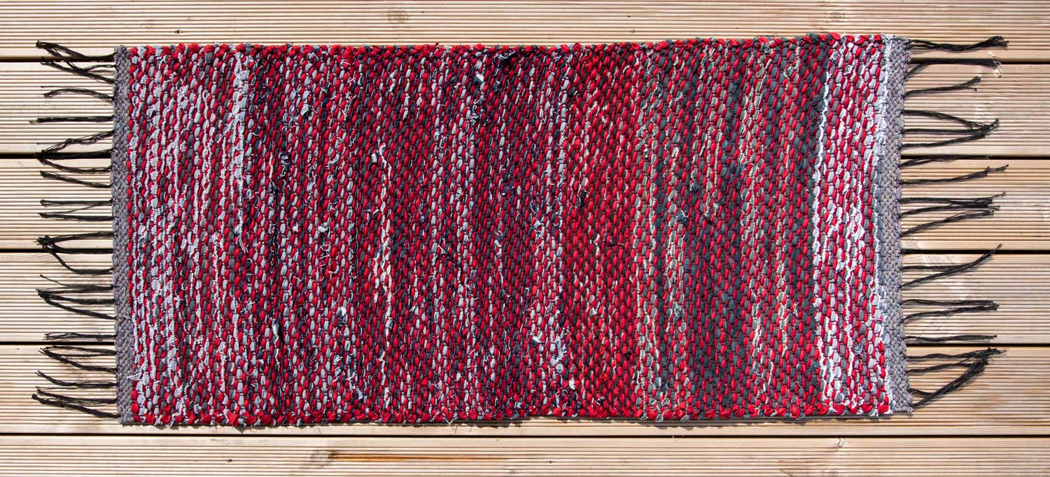 Terra Mama kaltsuvaip mustadest teksaribadest ja punasest lindist "Kõva sõna"