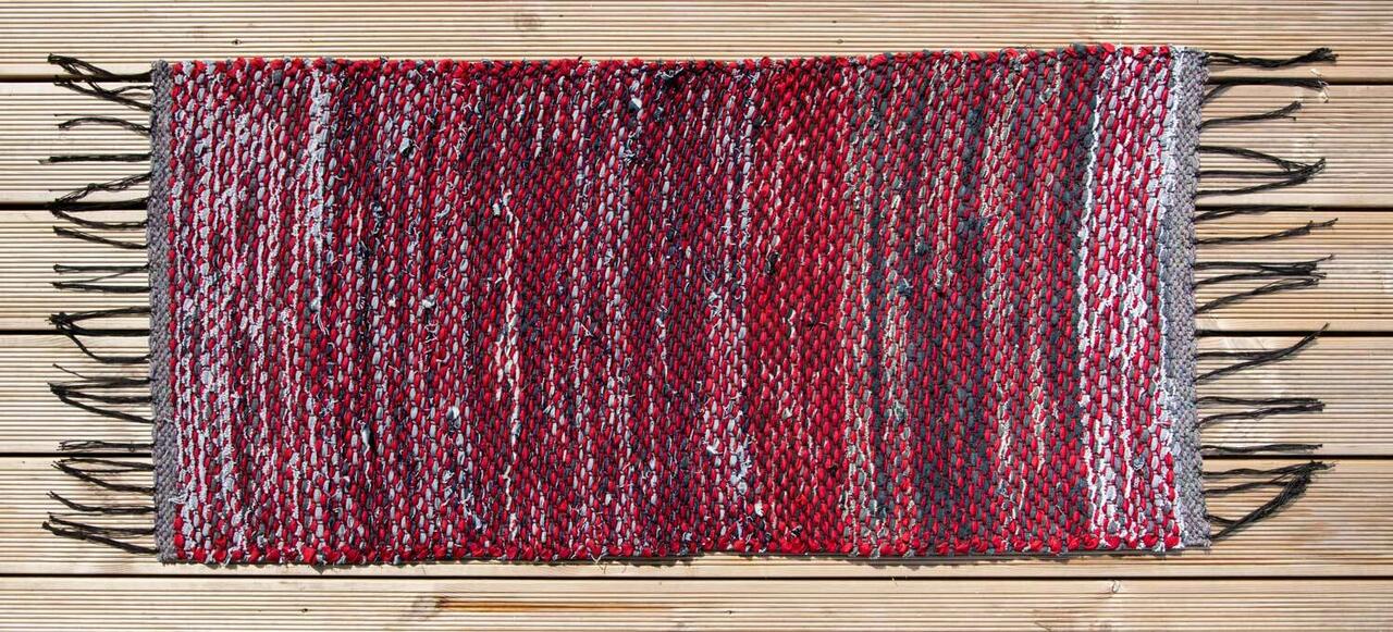 Terra Mama kaltsuvaip mustadest teksaribadest ja punasest lindist "Kõva sõna"