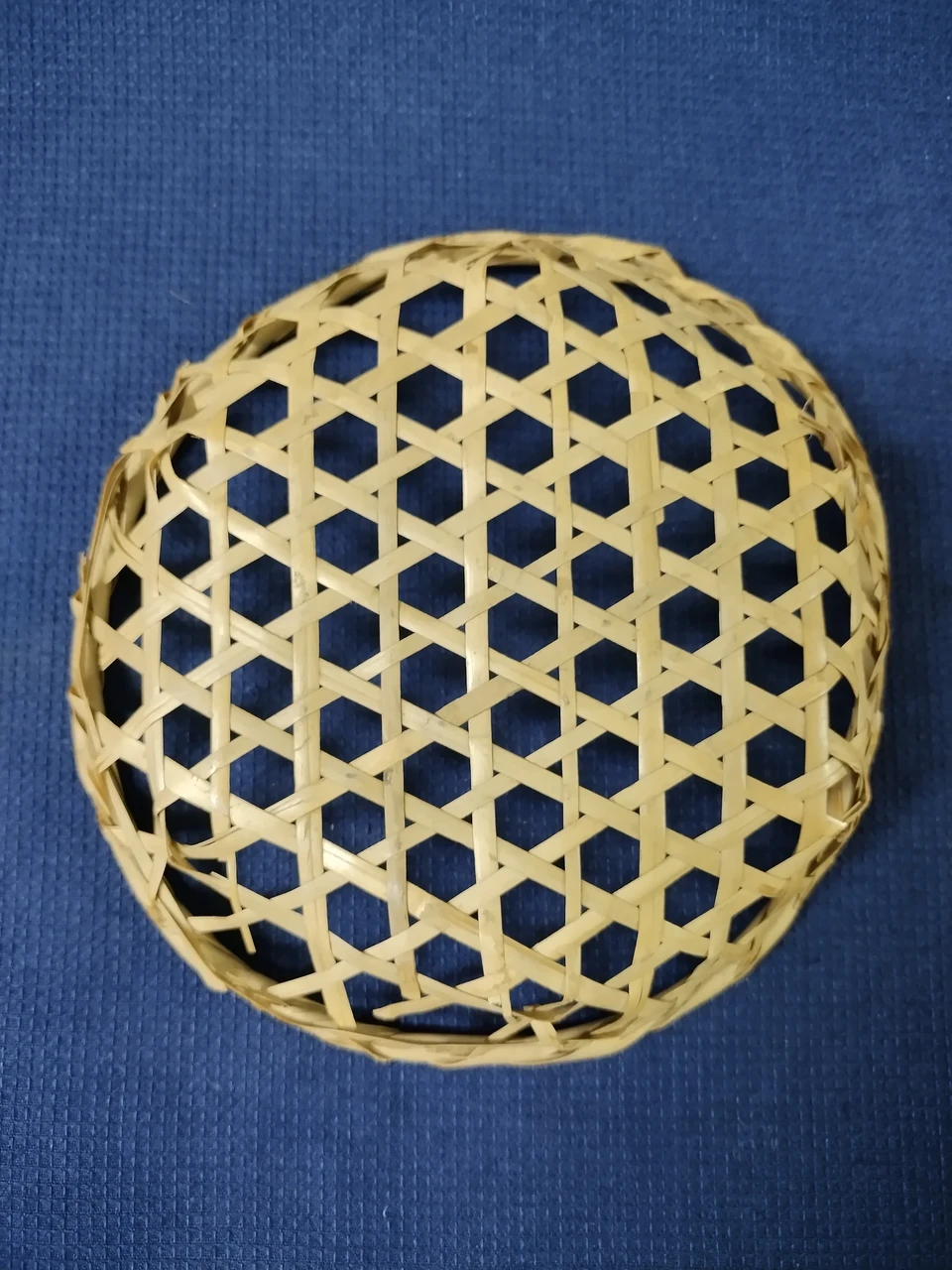 A small bamboo basket we use at home for snacks. Its woven pattern reminds me of a honeycomb structure.