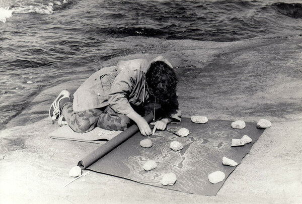 Eve Selisaar teeb kaljujooniste koopiat. mustale paberile. Äänisjärv, 1980ndad.rv, 