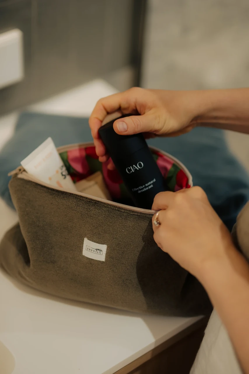 Uduvilla pruun terry tualett-tarvete kott Uduvill logoga, avatud ja täidetud kosmeetikatoodetega