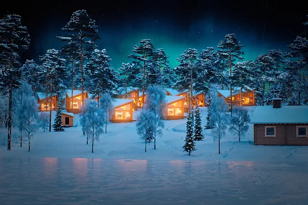 Two-story glass wall showcasing serene Pyhäjärvi lake and fells at dawn