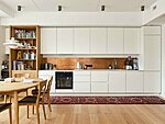 white bespoke kitchen with a ceramic worktop, veneer bookshelf and a minibar