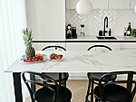 white kitchen with ceramic worktop, dining table is designed by us and made from the same material as the worktop