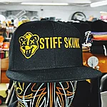 Stiffskunk black cap yellow logo 1