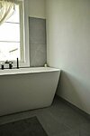 Keraamiliste plaatide ja lubimarmorino kombinatsoon vannitoa seintel