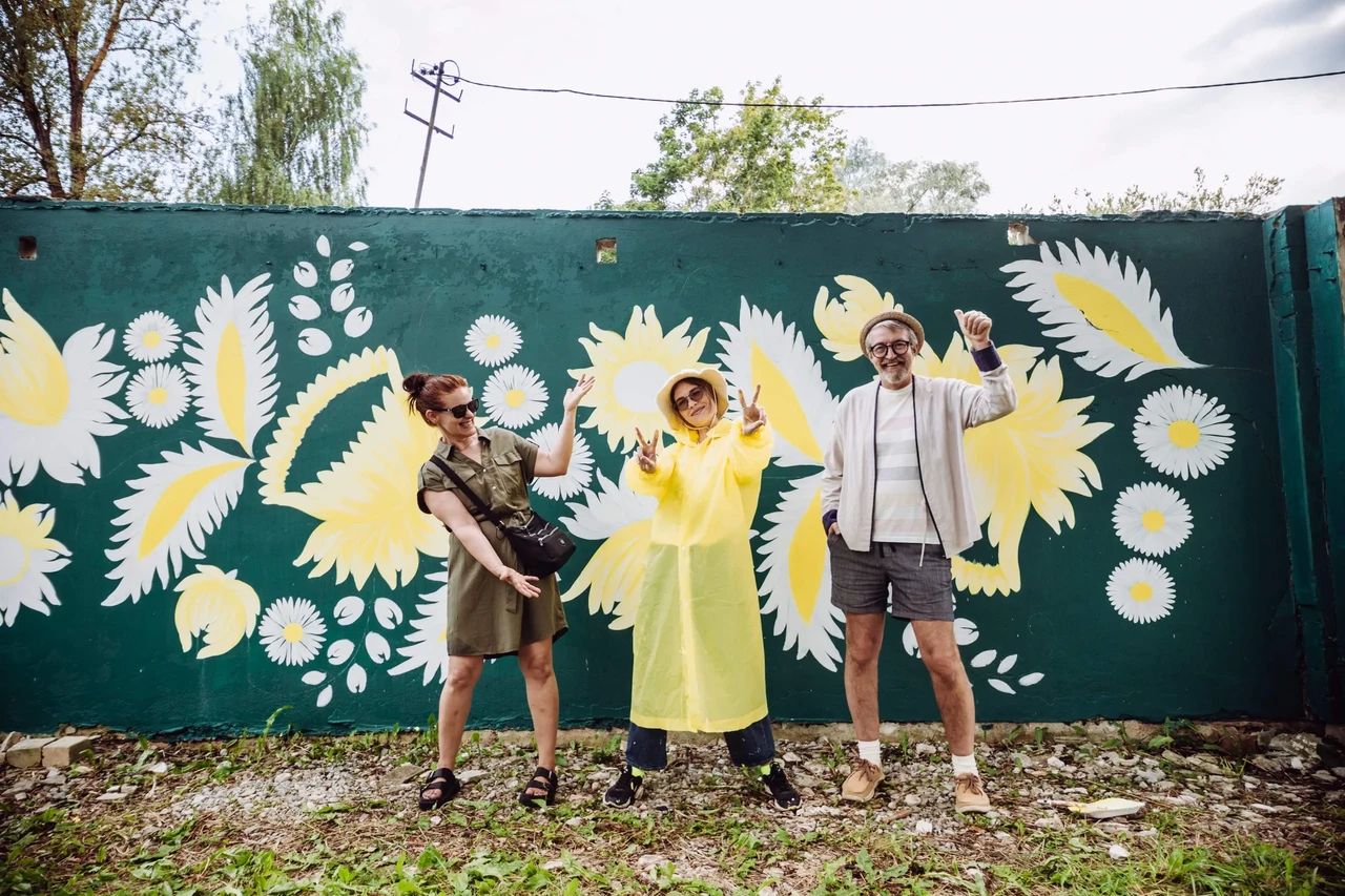 Viktoria Berezina (keskel) koos Kaili Kase ja Raul Oreškiniga  valmiva seinamaali ees Mikro-Veneetsias.