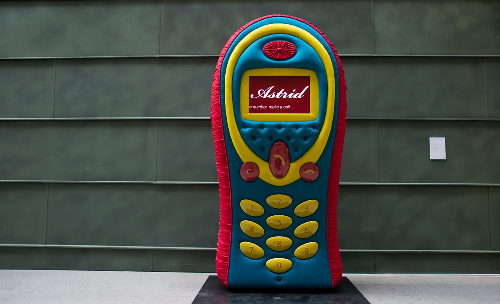 MOBIILTELEFON &quot;Astrid&quot; – kunstiprojektina valminud polsterdatud telefon - kõrgus 2,2m. Idee Riin Rõõs, Eve Arpo, it-lahendus/elektriosa Erik Bartske, mahuline lahendus ja teostus Kalmer Allik. Asukoht KUMU kunstimuuseum.