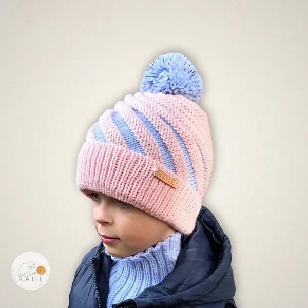 Pastel pink and light blue kids reflective beanie – hand-knitted merino wool winter hat with pom-pom by RAHEcraft. Soft reflective knit hat handmade in Estonia, perfect winter gift.