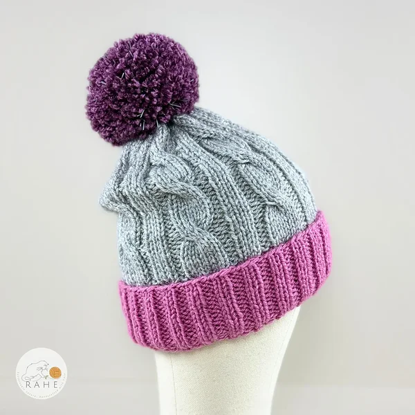 Pink, grey, and purple knitted cable knit winter beanie with a reflective bobble. For kids, and adults alike. Estonian handicraft gifts.