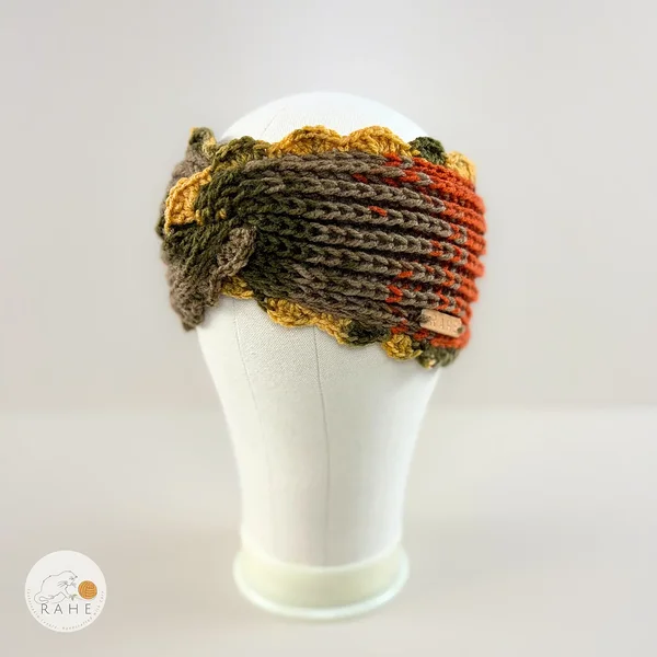 Hand-knitted wide acrylic headband on mannequin head, moss green, orange, beige, and mustard yellow gradient headband with twisted detail, fisherman's rib knit texture, crocheted scalloped edge, RAHEcraft