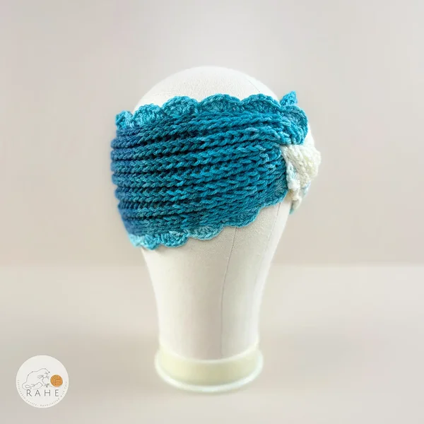Hand-knitted wide acrylic headband on mannequin head, white and bright blue gradient headband with twisted detail, fisherman's rib knit texture, crocheted scalloped edge, RAHEcraft