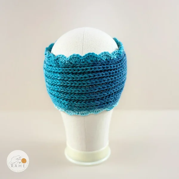 Hand-knitted wide acrylic headband shown from the back on a mannequin, white and light blue gradient headband with ribbed knit texture and hand-crocheted scalloped edge, RAHEcraft