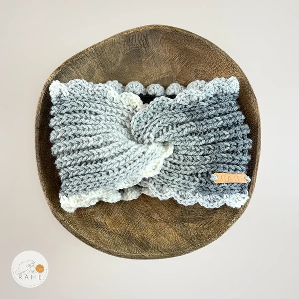 Flat lay of hand-knitted wide acrylic headband in white and grey gradient, twisted front detail and crocheted scalloped lace edge, handmade knit accessory, RAHEcraft
