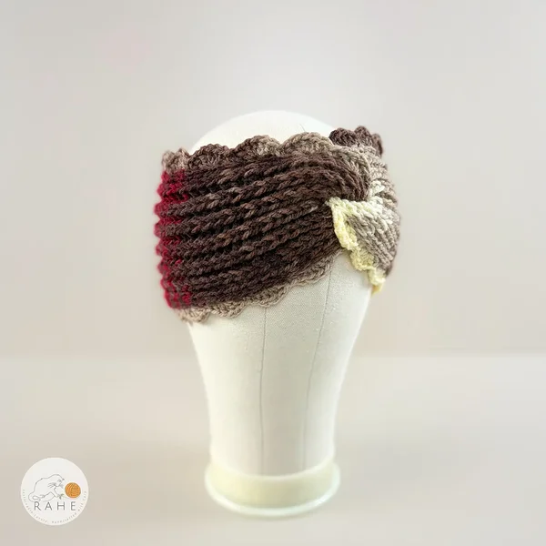 Side view of a hand-knitted wide acrylic headband with twisted texture, neutral brown tones, crocheted scalloped lace edge, mannequin display, RAHEcraft