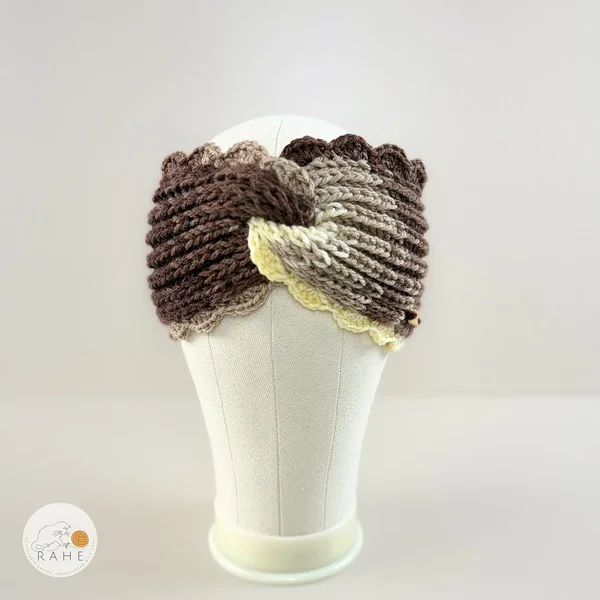Hand-knitted wide acrylic headband with twisted center, brown and beige tones, crocheted scalloped lace edge, displayed on a mannequin, RAHEcraft
