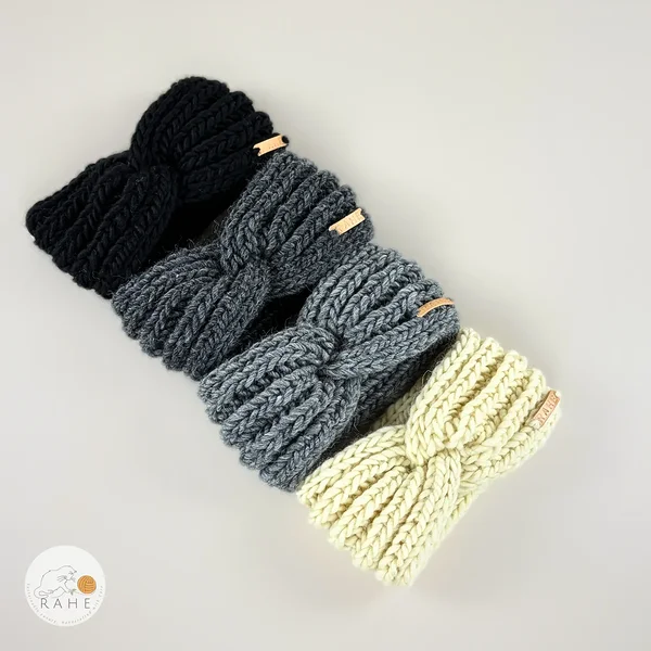 a selection of four flat laid headbands, hand-knitted in chunky wool, black, charcoal, grey, and ivory white