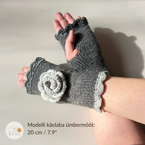 RAHEcraft käsitsi kootud sõrmedeta kinnas hallis toonis tume- ja helehalli pitsilise ääre ja heegeldatud lillega. Pildil on näha kinnaste istuvus – modelli käelaba ümbermõõt on 20 cm (7.9").