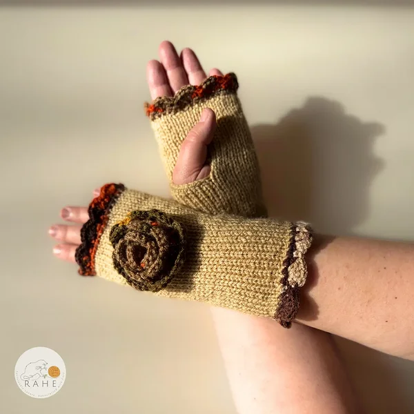 RAHEcraft hand-knitted fingerless gloves in beige with orange-brown edging and a crocheted flower. The smooth knit keeps wrists warm and adds a romantic handmade touch.