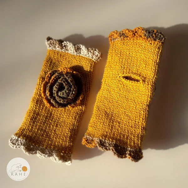 Hand-knitted mustard yellow fingerless gloves with lace edging, a crocheted flower and thumb opening – Nordic autumn inspired handmade design.