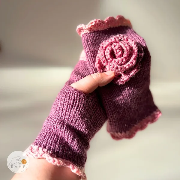 Single RAHEcraft hand-knitted fingerless glove in berry pink with soft pink lace edging. The soft smooth knit is comfortable and flexible for everyday wear.