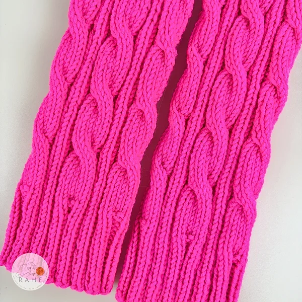 RAHEcraft neon pink merino wool leg warmers close up cable knit texture, handmade soft knit detail showing braided cable pattern, high quality cozy knitwear for women 