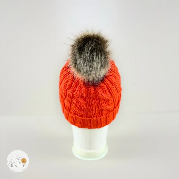 Back view of an orange hand-knitted merino wool children’s hat with faux fur pom-pom by RAHEcraft