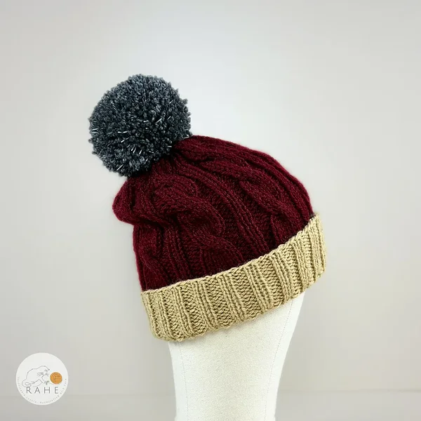 Hand-knitted winter hat in burgundy with a large grey reflective pom pom. Double non-slip ribbed brim in beige. Handmade in Estonia.