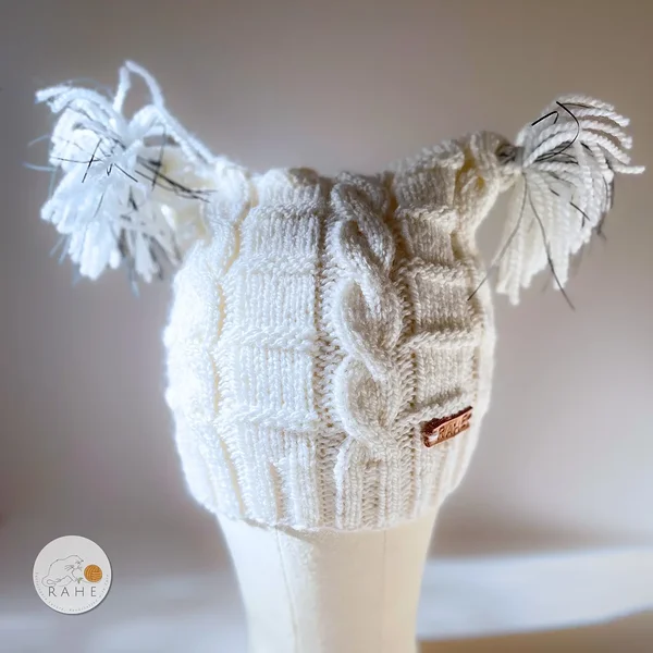 White cable-knit kids’ reflective beanies, hand-knitted wool blend winter hats. Estonian handicraft, warm ski hat and gift idea.