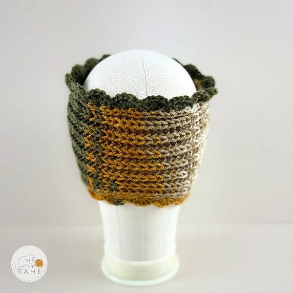 Hand-knitted wide acrylic headband shown from the back on a mannequin, forest green and dark yellow  gradient headband with ribbed knit texture and hand-crocheted scalloped edge, RAHEcraft