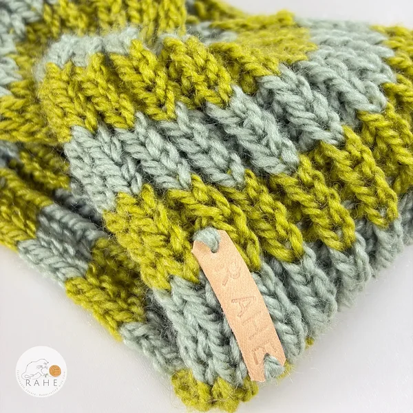 Hand-knitted wool blend headband for women in sage and olive green tones, featuring a soft ribbed knit texture and a sewn RAHE label, detailed close-up view.