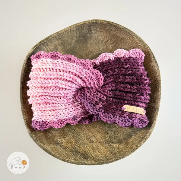 Hand-knitted wide acrylic headband in gradient white, pink, and purple,  fisherman’s knit with hand-crocheted scalloped edge, flat lay product photo, RAHEcraft
