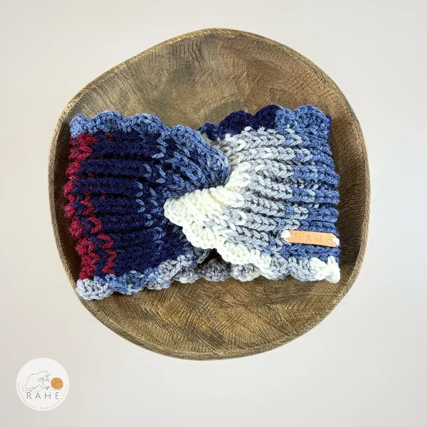 Hand-knitted wide headband laid flat in a wooden bowl, blue, grey, white and burgundy color transition, scalloped crochet edge, women’s knitted headband, RAHEcraft