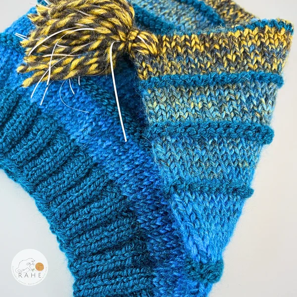 Close-up of knit texture and reflective tassel detail on a handmade hat for all ages