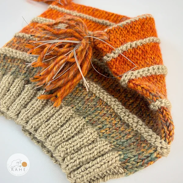 Close-up of ribbed knit texture and gradient colorwork in orange and beige